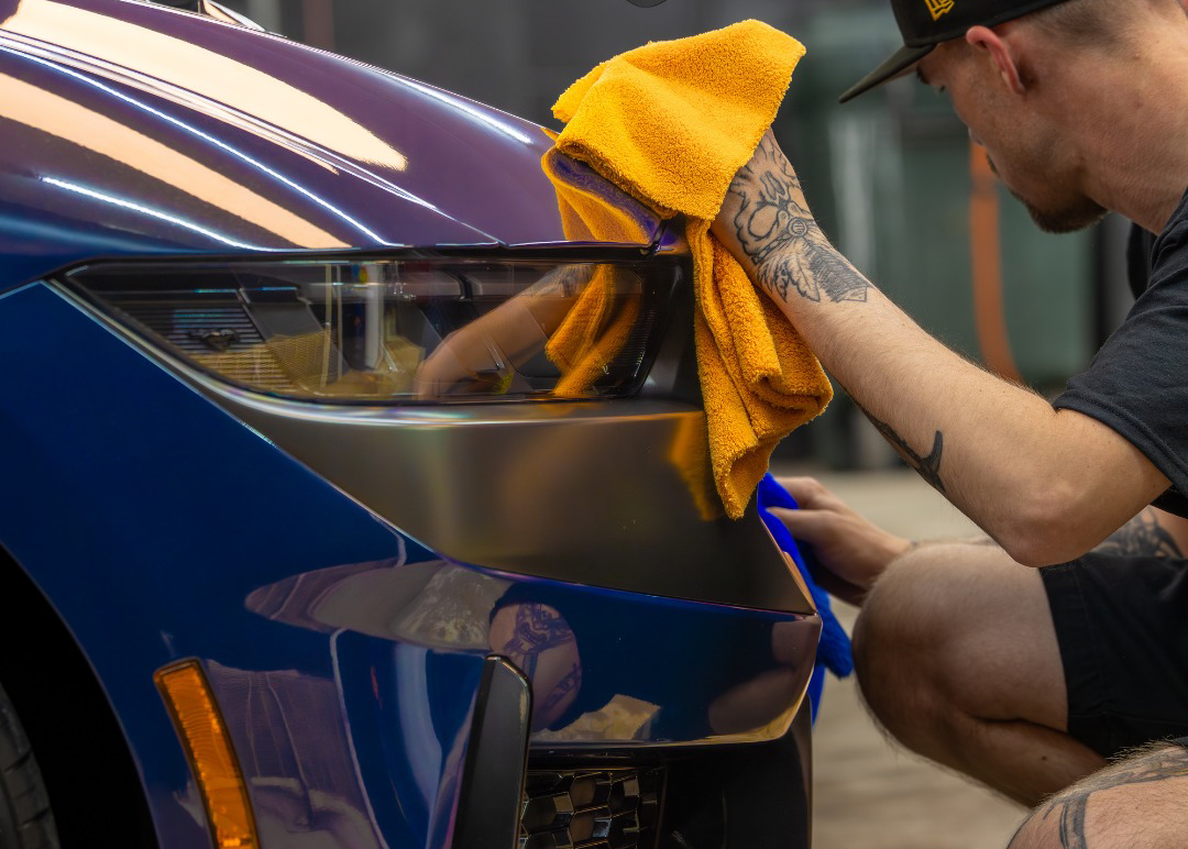 Technician wiping vehicle with microfiber towel at Paint Slayer Auto Spa